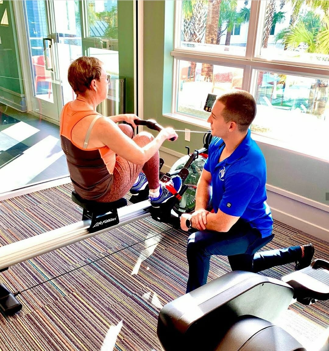 Jake coaching a client's rowing machine form
